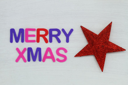 Merry Christmas written with colorful letters on wooden surface and red heart with glitterの写真素材