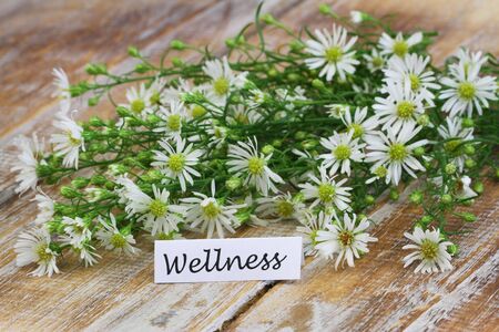 Wellness card with chamomile flowers on rustic wooden surfaceの写真素材