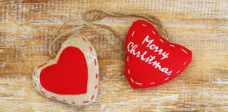 Merry Christmas card with hearts canvas on wooden surfaceの写真素材