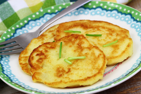 Crispy potato fritters garnished with spring onionsの写真素材