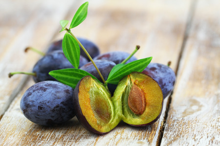 Fresh plums on rustic wooden surface with copy spaceの写真素材