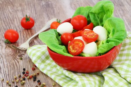 Mozzarella salad with cherry tomatoes in a rustic wooden surfaceの写真素材