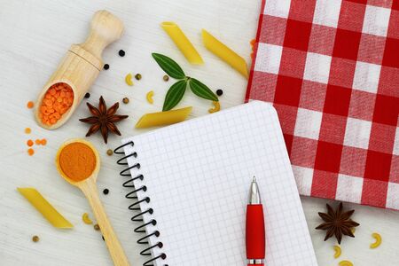 Empty notebook with pen and different ingredients spread around itの写真素材