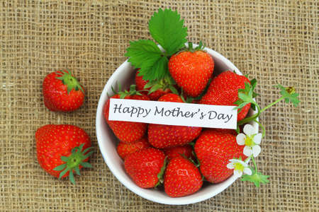 Happy Mother's Day card with bowl of fresh strawberries on burlap backgroundの写真素材