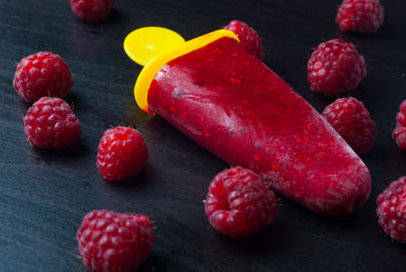 ice lolly raspberries on black backgroundの写真素材
