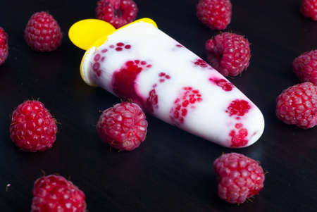 ice lolly raspberries on black backgroundの写真素材