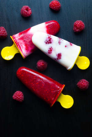 ice lolly raspberries on black backgroundの写真素材