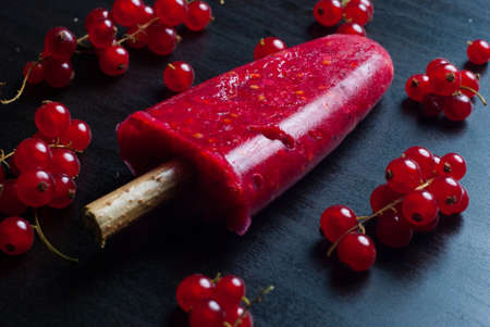 ice lolly with currants on a dark backgroundの写真素材