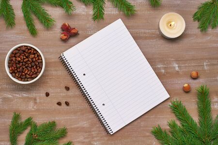 Christmas song from the notebook, fir branches, candles burning hazelnuts and pine nuts on the old Boardの写真素材