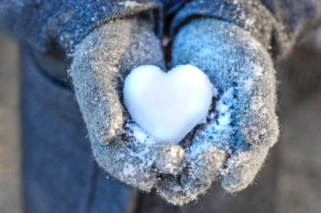 Holding a heart of snow in her handsの写真素材