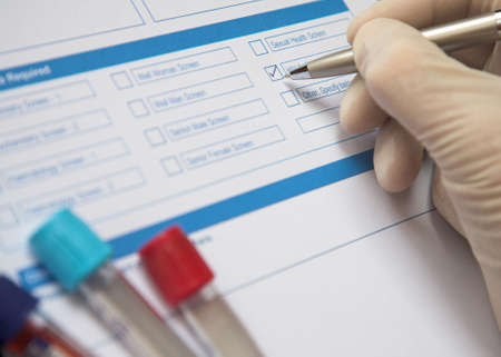 Doctor ticking box on a blood test formの写真素材