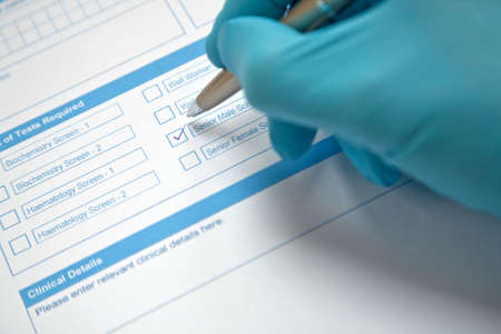 Doctor filling in a blood test formの写真素材