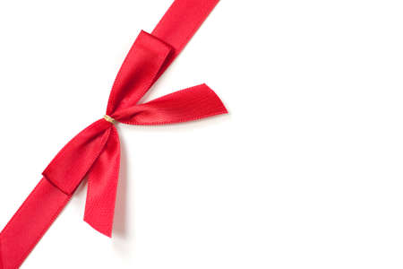 Red sild ribbon, tied in a bow on a white background.の写真素材