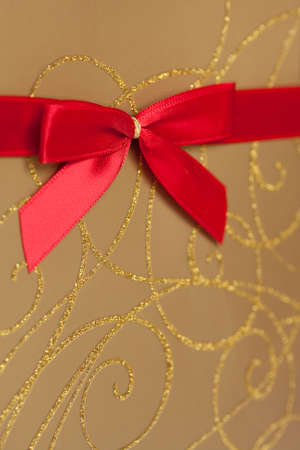 Detail of gold wrapped present with red bow decorationの写真素材