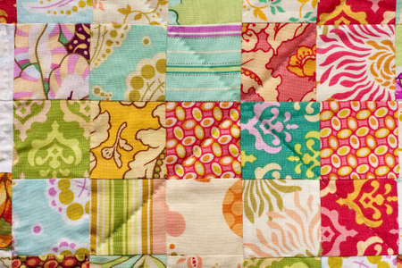 Detail from a handmade patchwork quilt made with squares.の写真素材