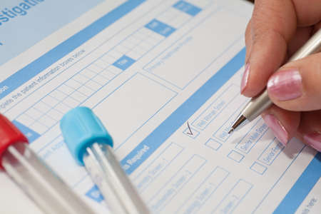 A lady doctor requesting a blood test, with sample tubes ready.の写真素材
