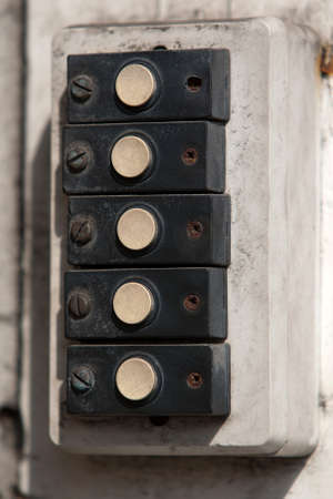 Row of old doorbells on an abandoned buildingの写真素材