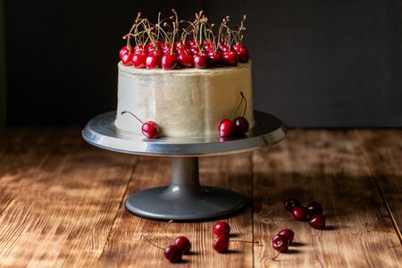 Red velvet cake with sweet cherry on a wooden tableの写真素材