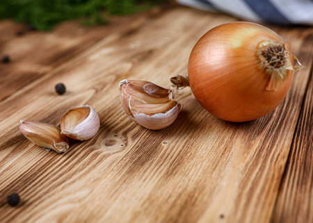 Onions and garlic on wooden tableの写真素材