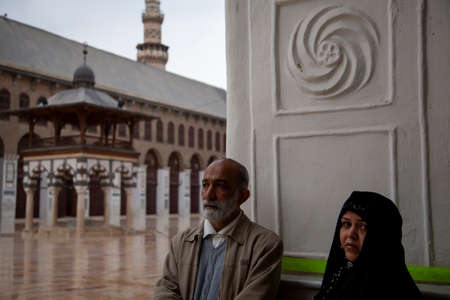 Damascus, Syria 03/28/2010: A religious elderly couple is waiting at the gate of the Great Mosque of...