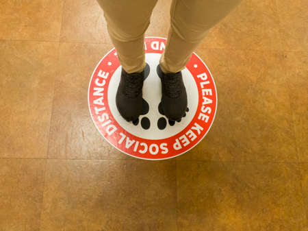 07/22/2020 Maryland, USA: The new normal in COVID-19 era.  US retail stores, supermarkets and groceries put floor signs asking people to keep apart and do social distancing to limit spread of disease.のeditorial素材