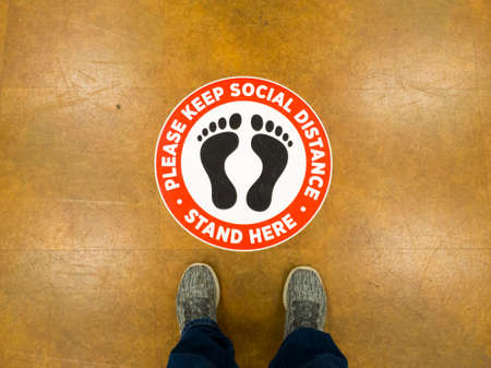 07/22/2020 Maryland, USA: The new normal in COVID-19 era.  US retail stores, supermarkets and groceries put floor signs asking people to keep apart and do social distancing to limit spread of disease.のeditorial素材