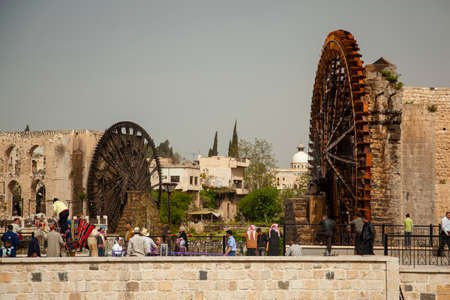 Hama/Syria 03/27/2010: Cityscape of Syrian city of Hama, with historic waterwheels (Norias)  in the...