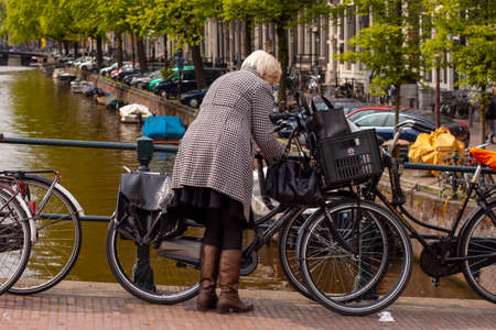 Amsterdam, Netherlands 05/16/2010: A well dressed elderly woman wearing leather boots and a...