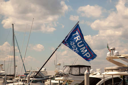 Stensville, MD ,USA 08/18/2020: Trump 2020 flag waving on a flag post at the back of a boat.のeditorial素材