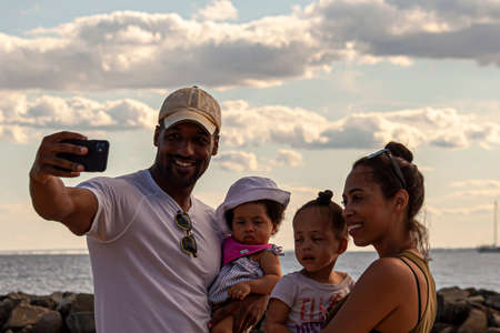 Rock Hall, M, USA, 08/30/2020: A young and happy African American family is taking a selfie at the...