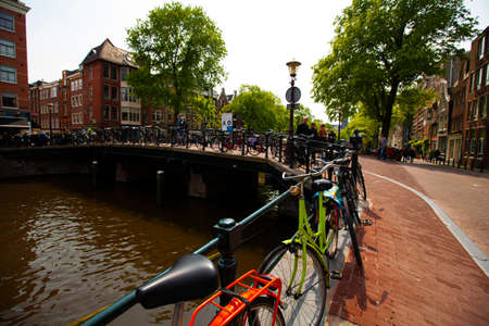Amsterdam, Netherlands 05/15/2010: Amsterdam has a deep cycling culture. Bikes are seen everywhere. Image shows a long line of bikes locked to the railings of a bridge on a canal at the city center.のeditorial素材