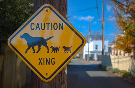 Close up isolated image of a yellow metal Animal Crossing sign with a mother dog and her puppies...