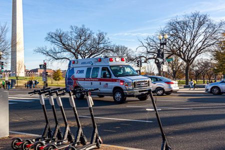 Washington DC, USA 11-29-2020: An American Medical Response Ambulance is rushing to an emergency with bells and whistles on the Constitution Avenue. Medical Personnel wears face mask due to COVID-19のeditorial素材