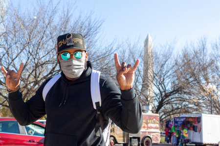Washington DC, USA 11-29-2020: A young hispanic man wearing baseball hat, polarized designer...