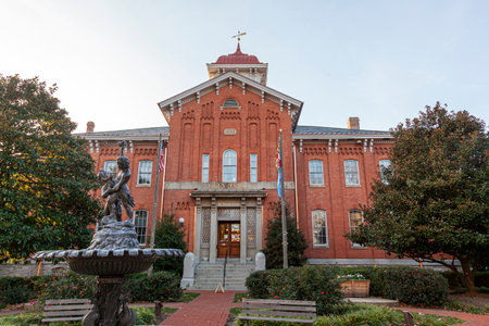 Frederick, MD, USA 11.24.2020: Frederick County City Hall Building. The historic brick building with arched windows, and a tower is built on 1862. There is a US flag and Maryland Flag in front of itのeditorial素材