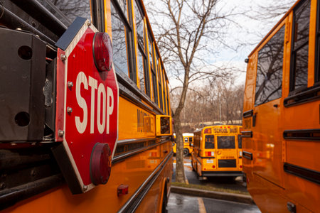 A close up image of yellow American school bus with selective focus on the stop sign on the side....