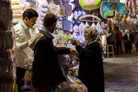 Damascus, Syria 03-28-2010: An Arabic woman wearing hijab is shopping at an apparel and baby clothing store in the historic Al Hamidiyah Souq. She is bargaining with the shop keeper on the price.のeditorial素材