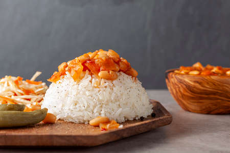 Bean stew over rice pilaf known as Pilav ustu kuru fasulye is a popular dish in Turkey where haricot beans stewed with spice and tomato sauce is transferred on top of butter cooked rice pilau.の写真素材