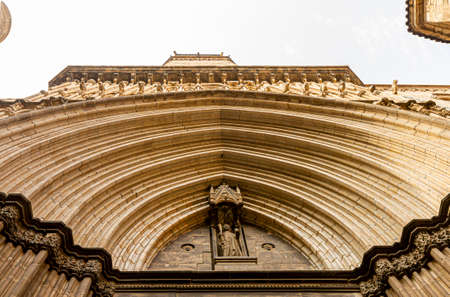 Famous 13th century Gothic Architectural masterpiece Barcelona Cathedral a.k.a Cathedral of the Holy Cross and Saint Eulalia. Image features the low angle view of the entrance door from outside.の写真素材