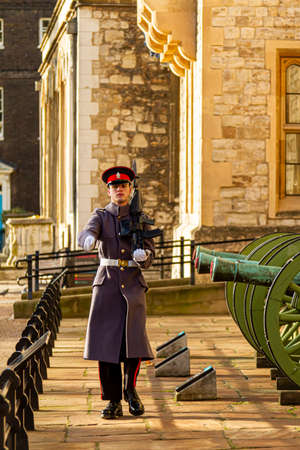 London, UK 11-18-2012: A young caucasian British soldier is on sentry duty in the tower of London. He is marching in front of artilleries with his rifle in hand. A ceremonial duty. Rifle has bayonet.のeditorial素材