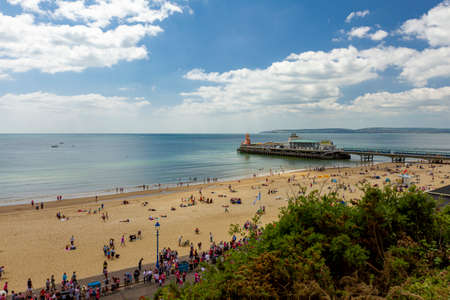 View of the Bournemouth beach and pier as well as scenic calm Atlantic ocean and blue sky. Aerial,...