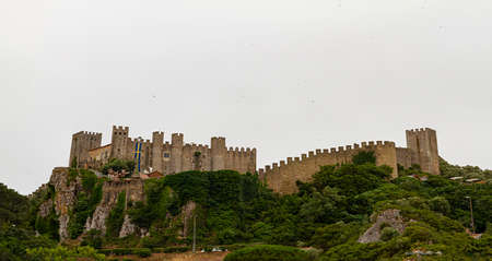 Obidos, Portugal is a walled city with well preserved castle and walls surrounding the hilltop settlement. These medieval stone structures as well as traditional houses inside the walls are touristic.のeditorial素材