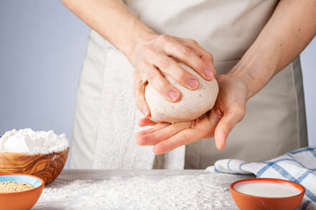 Preparation of homemadeTurkish flat bread, pide or pizza base in the kitchen. A woman chef is...