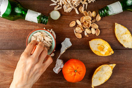 Untidy, messy after party table top view with sunflower seeds, pistachios, leftover shells  and...
