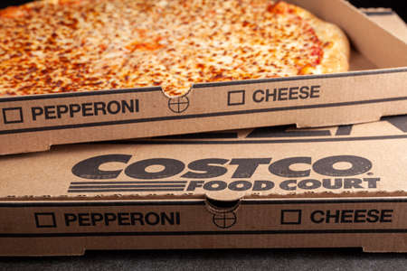 Clarksburg, MD, USA 04-7-2021: Closeup angled image of a carton box of delicious made to order COSTCO cheese pizza. Very popular bargain priced food court item from the wholesale giant.のeditorial素材