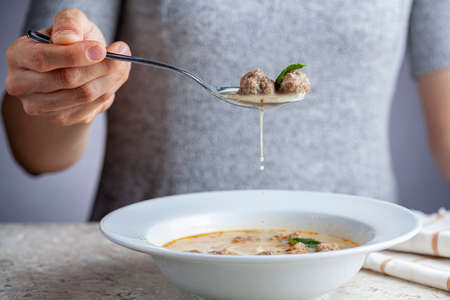 Turkish meatball soup (Terbiyeli kofte corbasi ) is a popular dish in Turkey where meatballs made with ground beef and rice are cooked in broth with egg mix and herbs and served hot with spices.の写真素材