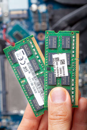 Close up isolated image showing an it technician or a consumer holding ram card in hand with an open...