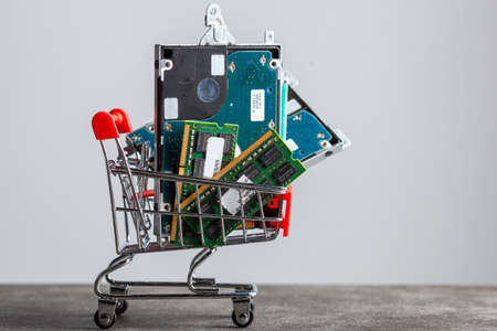 Clarksburg, MD, USA 04-07-2021: shopping cart filled with computer parts including RAM memory cards and a hard drive. Shopping for technology, consumer electronics, upgrading computer themes.のeditorial素材