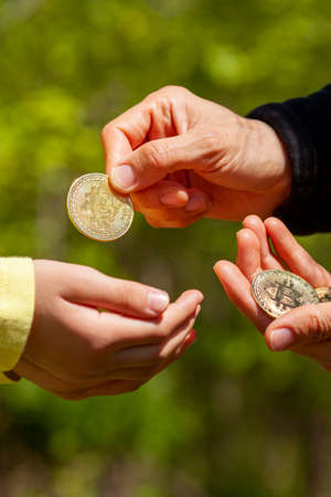 A child is asking for pocket money and her parent is giving a bitcoin coin in response.  Concept...