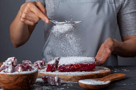 making of delicious fruit flavored homemade Turkish delight with vibrant pink red color and mixed...